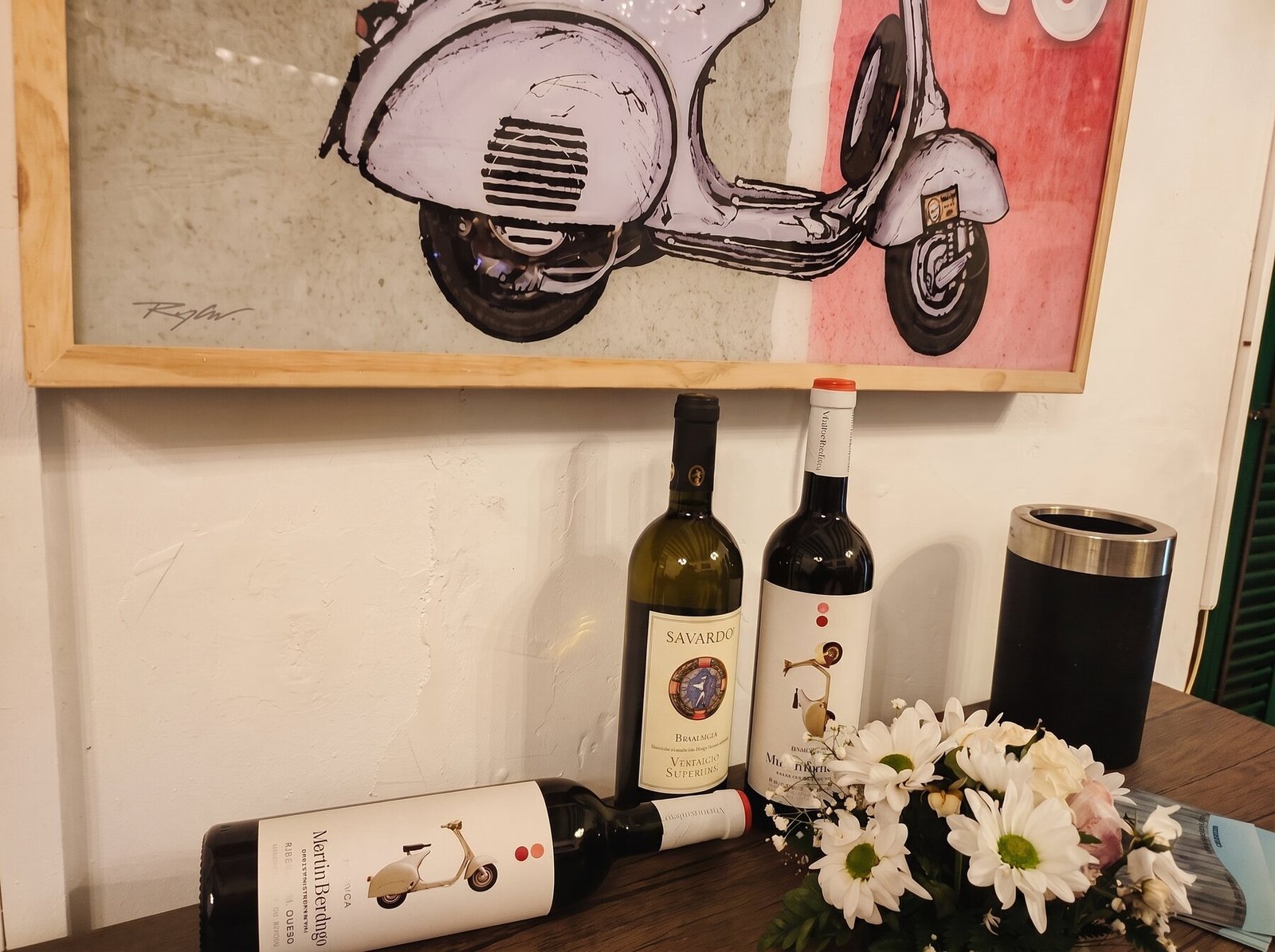Gemälde einer Vespa und Weinflaschen im Inneren von La Vespa, Artà